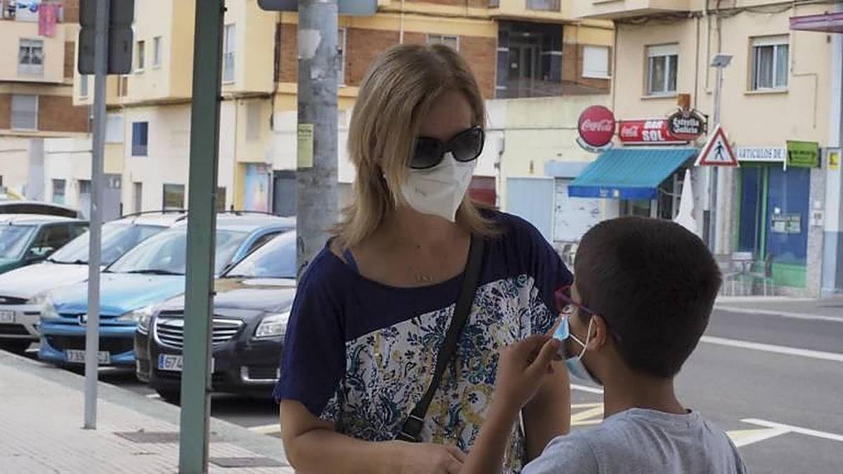 Un menor se coloca la mascarilla.