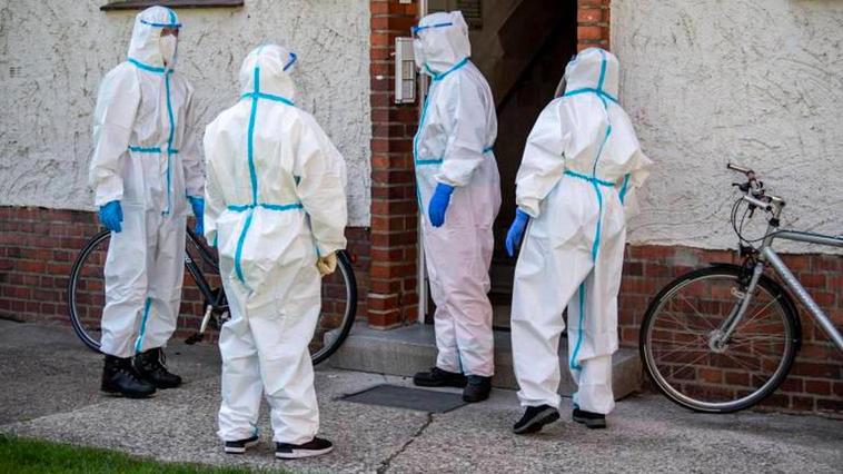 Voluntarios de Cruz Roja entran en un edificio de apartamentos para hacer pruebas de coronavirus.