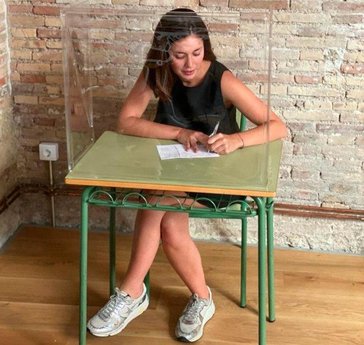 Mesa de colegio con una pantalla protectora.