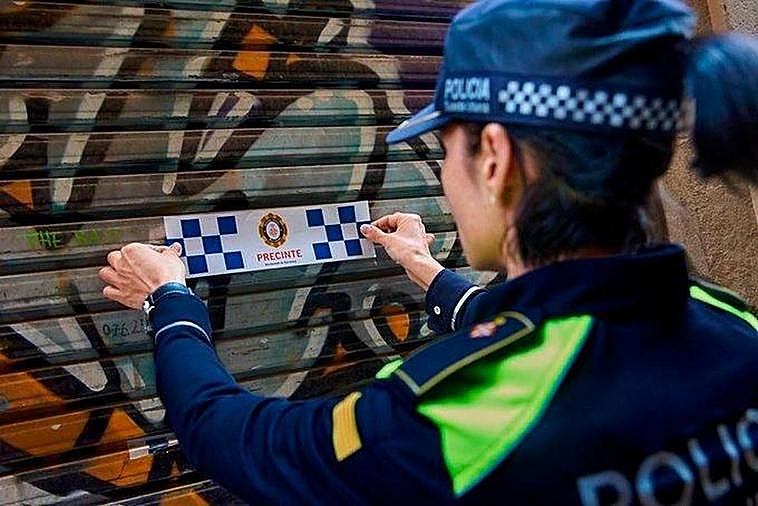 Una agente de policía coloca una etiqueta de precinto.