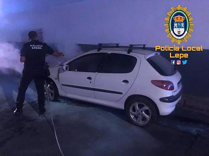 Agentes, en labores de extinción de un fuego en un turismo.