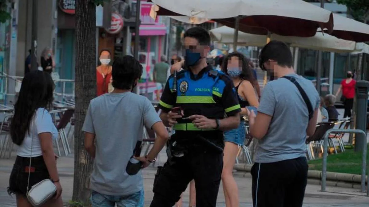 Un policía informa sobre la obligación de llevar mascarilla en la capital.