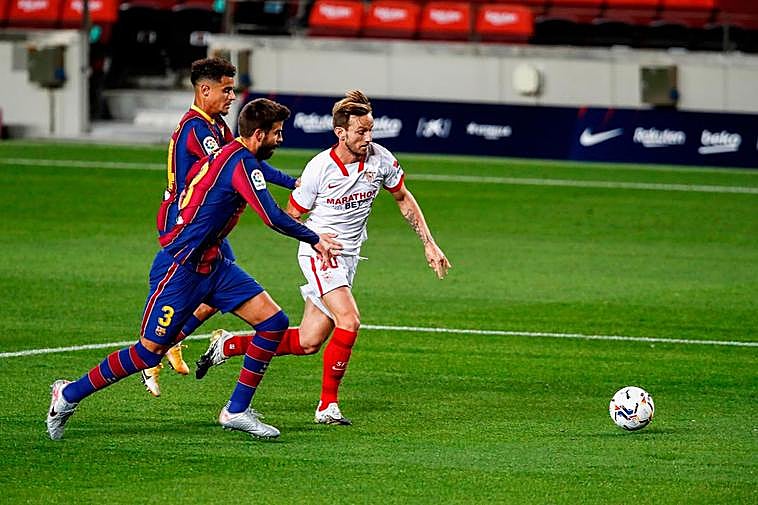 Piqué y Rakitic pugnan por un balón.