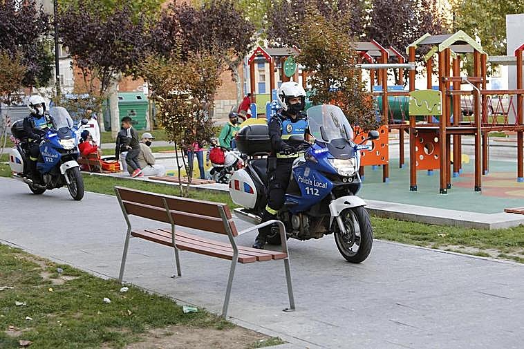 Dos agentes municipales en sus motos, por el parque de Garrido.