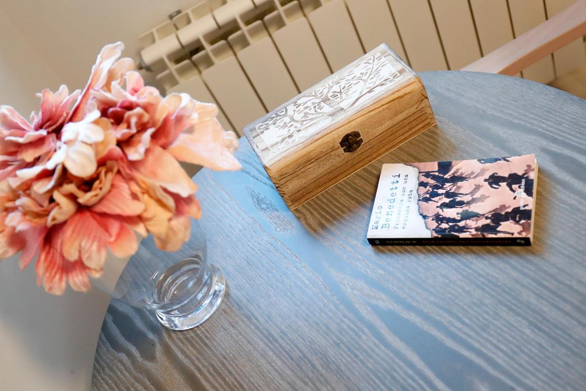 Detalle de un jarrón de flores y un libro sobre una mesa de una residencia de ancianos.