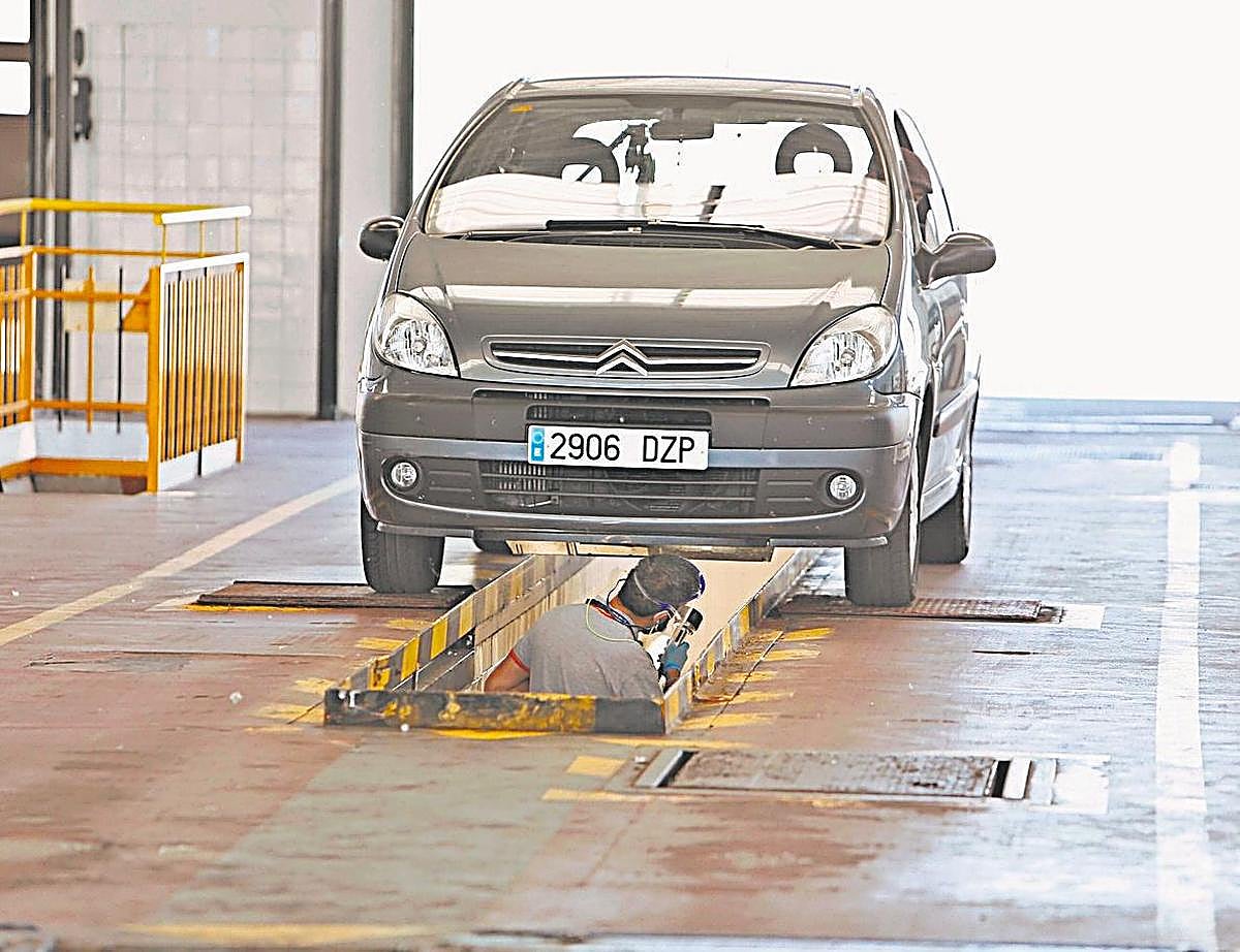 Operario revisando la parte baja del vehículo.