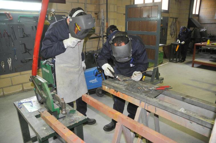 Dos participantes en un curso de formación de carpintería metálica.