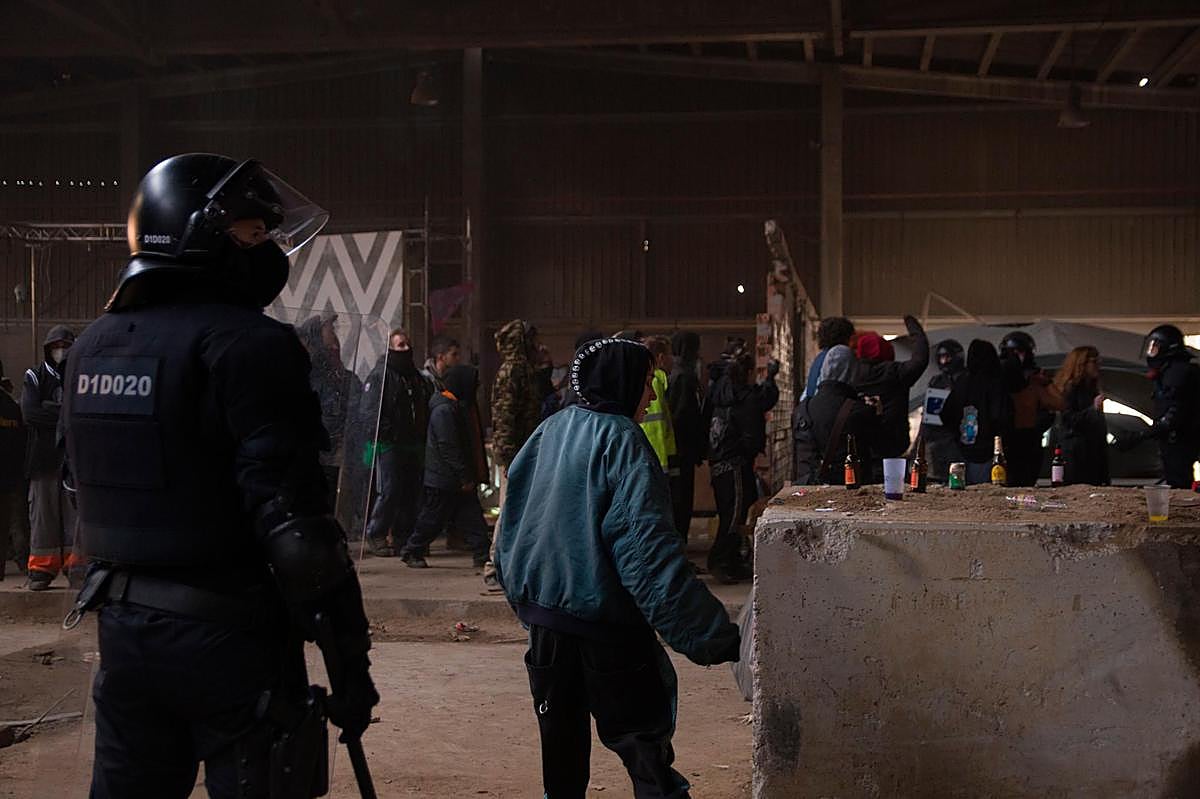 Un mosso d’esquadra frente a varios de los participantes en la ‘rave’.