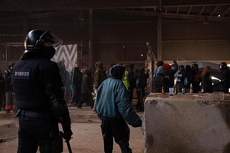 Un mosso d’esquadra frente a varios de los participantes en la ‘rave’.