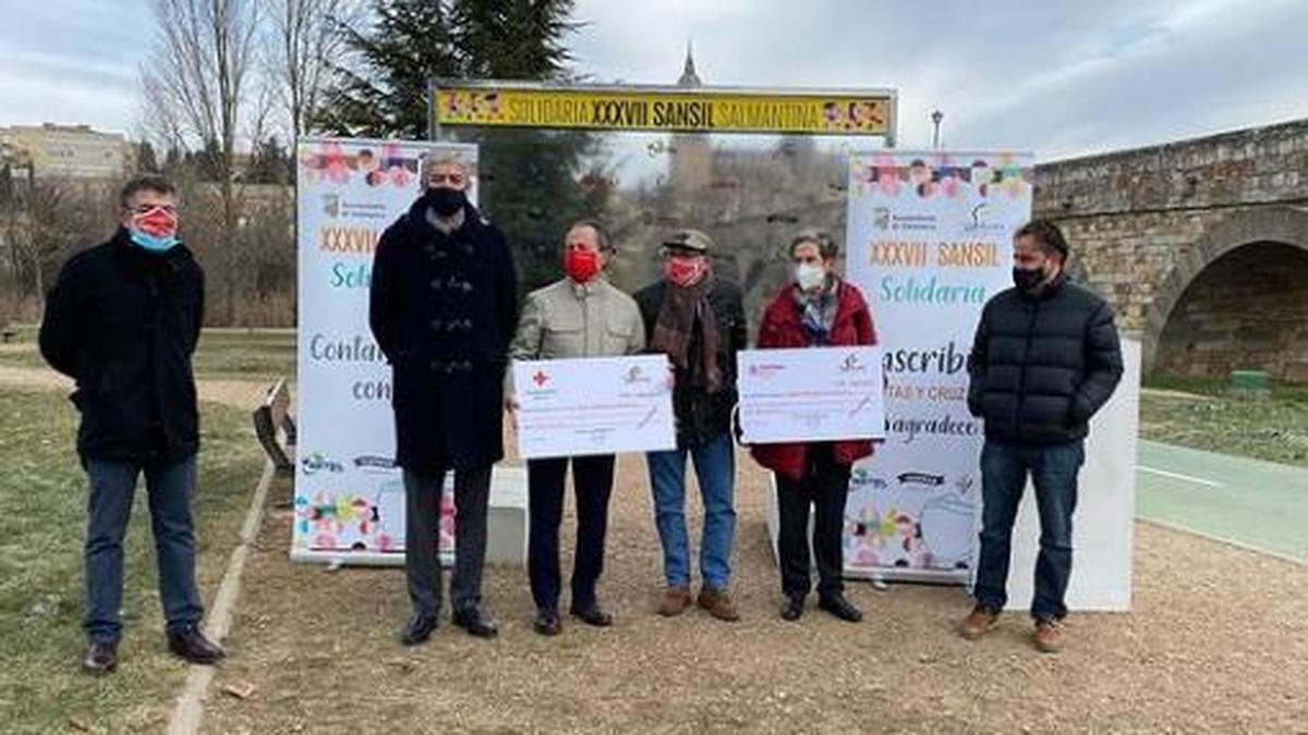 Momento de la entrega de los 14.000 euros del chip solidario junto al Puente Romano.