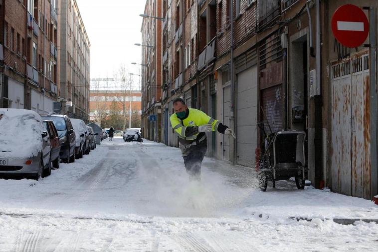 Un operario esparce sal en una calle de Garrido.