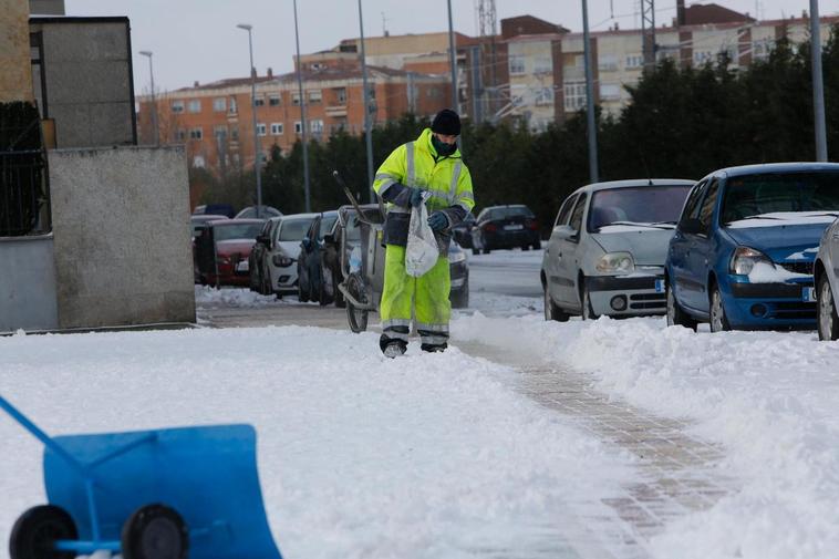 Un operario esparciendo sal por una calle salmantina.