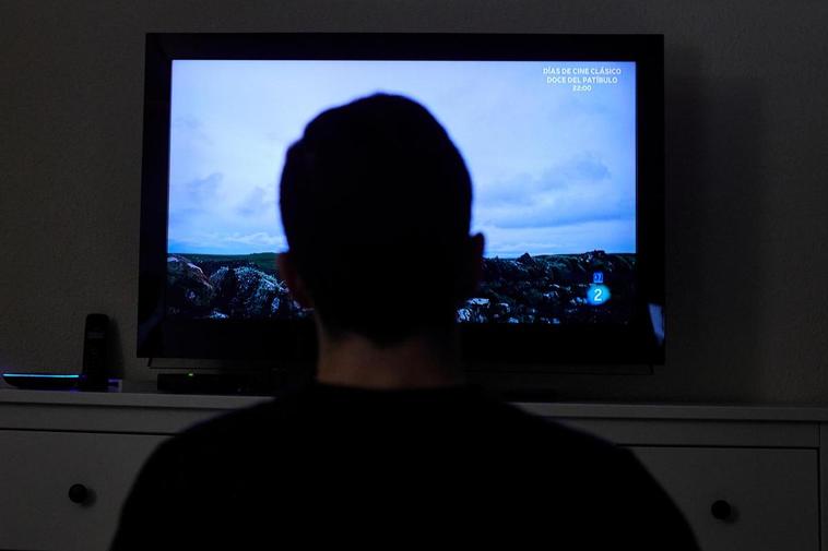 Un hombre ve la televisión en su casa