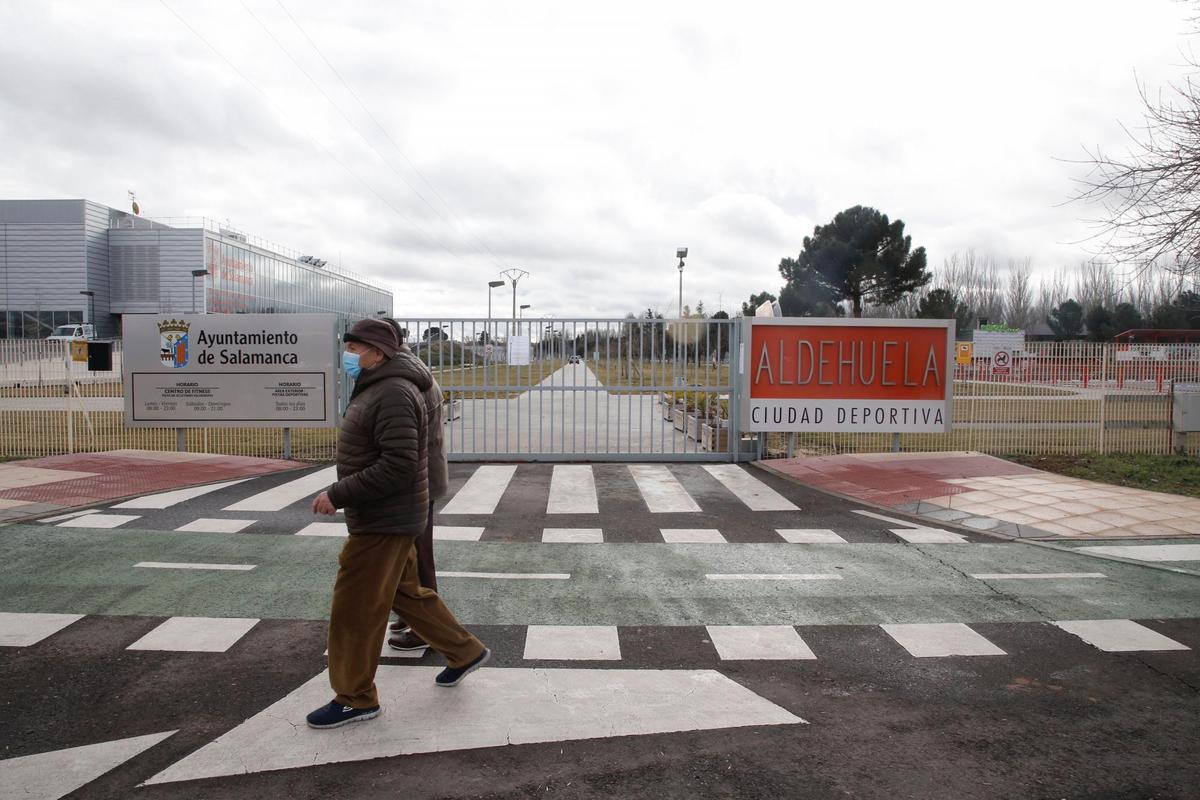 Dos personas pasean por delante de las instalaciones cerradas de La Aldehuela