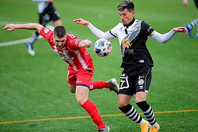 Garay, del Unionistas, pugna por un balón con un rival.
