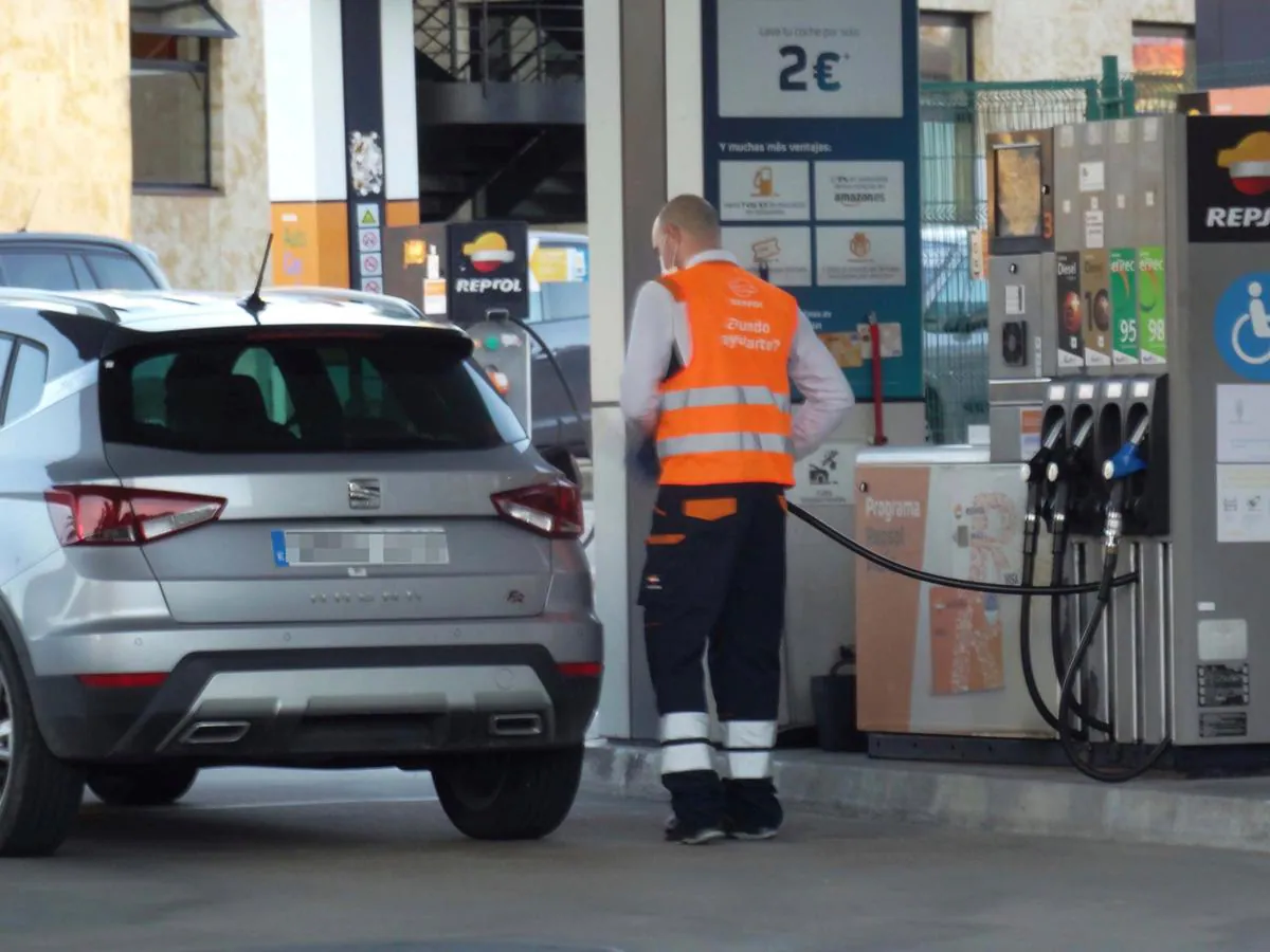 El empleado de una gasolinera repostando el coche de un cliente.