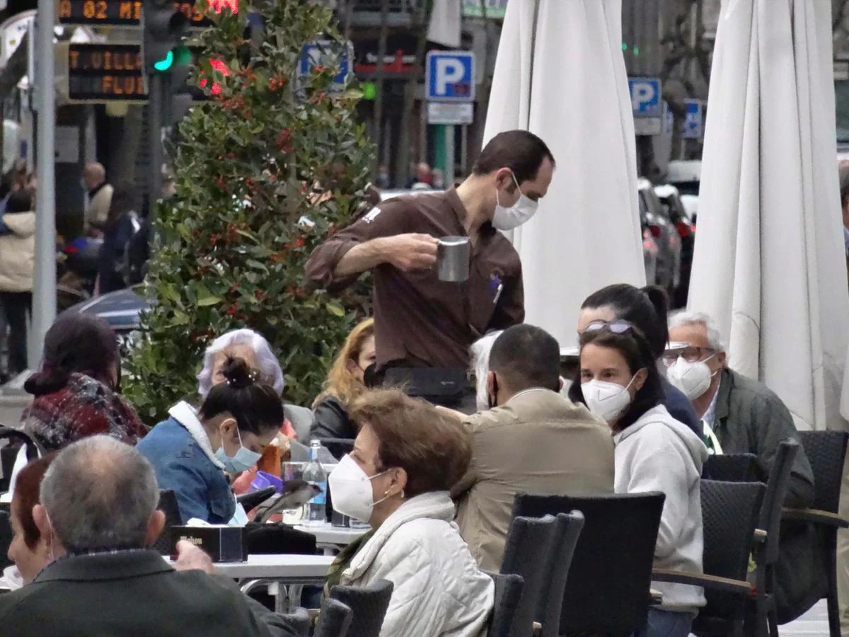 Un camarero atiende a varios clientes en una terraza en Salamanca.
