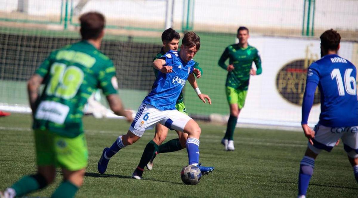 Andi busca recuperar el esférico ante un jugador del Oviedo B.