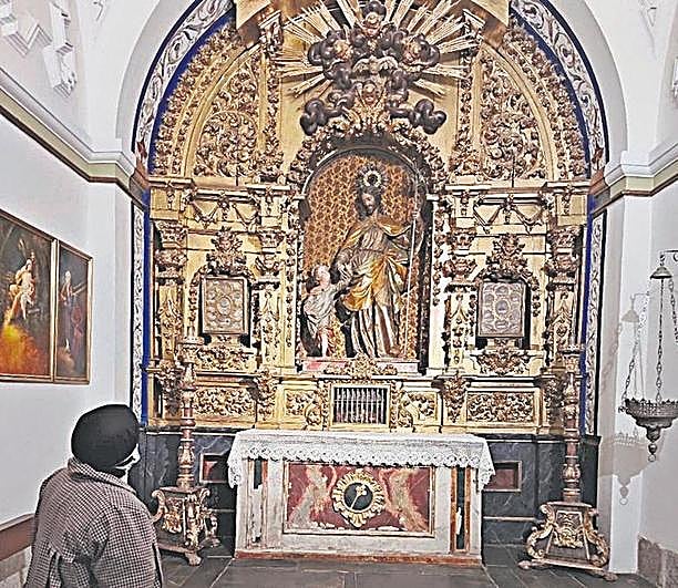 Una carmelita observando la humedad en la capilla de San José.