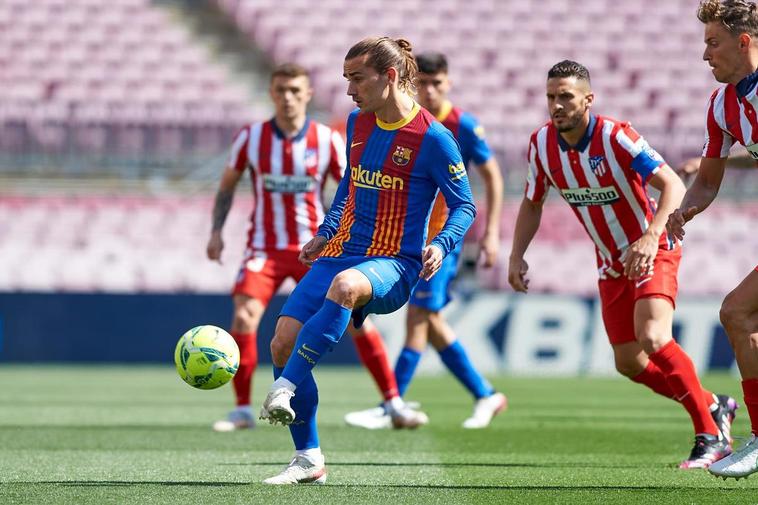 Griezmann disputa un balón ante sus antiguos compañeros.