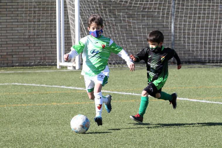 Un prebenjamín del Sporting Carbajosa trata de marcharse de otro pequeño del Jai Alai