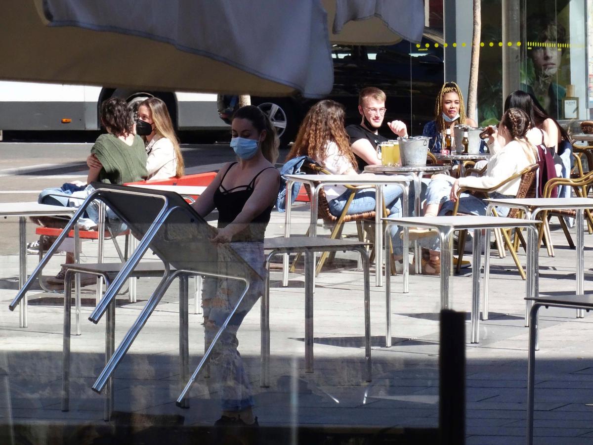 Una camarera coloca la mesa en la terraza de un establecimiento de hostelería de la capital.