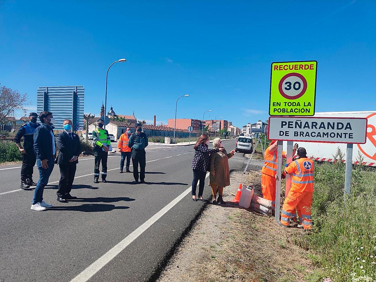 Carmen Ávila y Encarnación Pérez observan cómo los operarios colocan la nueva señalización.