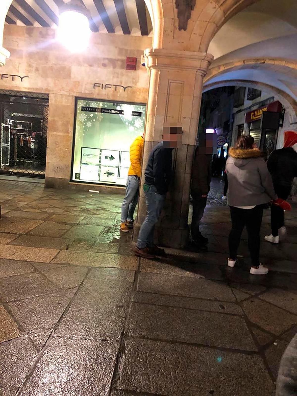 Un joven orinando en una de las columnas de la Plaza Mayor de Salamanca
