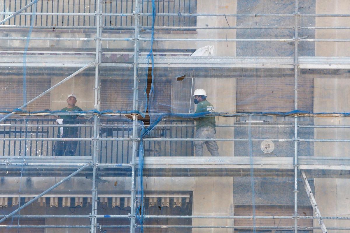 Trabajadores de la construcción, en las obras de rehabilitación de la fachada de un edificio.