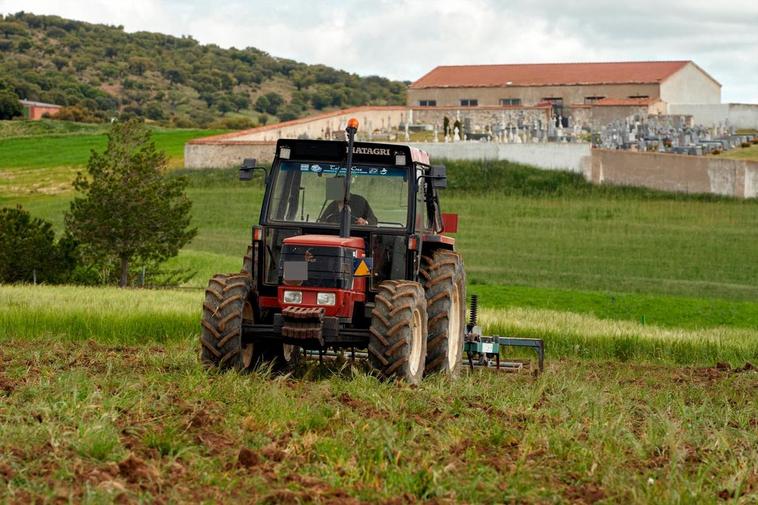 Un agricultor realizando labores con su tractor.