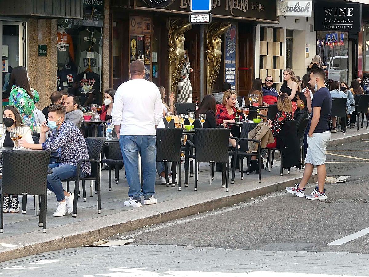 Un chico fuma apartado de la terraza.
