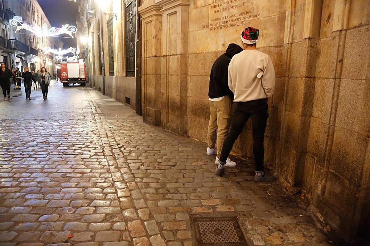 Dos jóvenes orinan en la calle Zamora, junto a la Plaza Mayor, en el último Fin de Año Universitario.