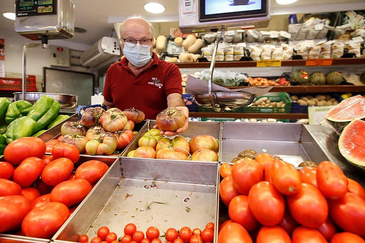 Candi, con su muestrario de diferentes variedades de tomate en su frutería.