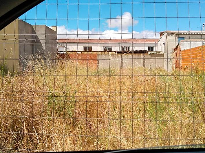 Un solar situado en pleno casco urbano y lleno de maleza seca con peligro de incendio.