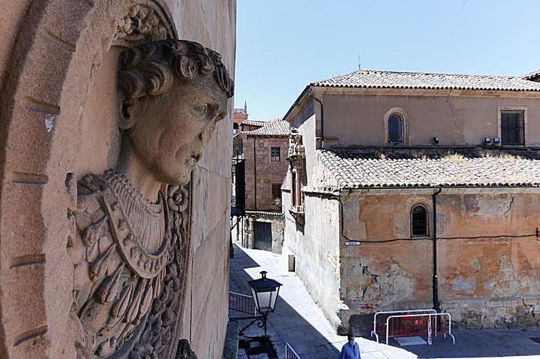 Uno de los medallones de la fachada de la casa de las Muertes. Al fondo, el final de la calle Bordadores.