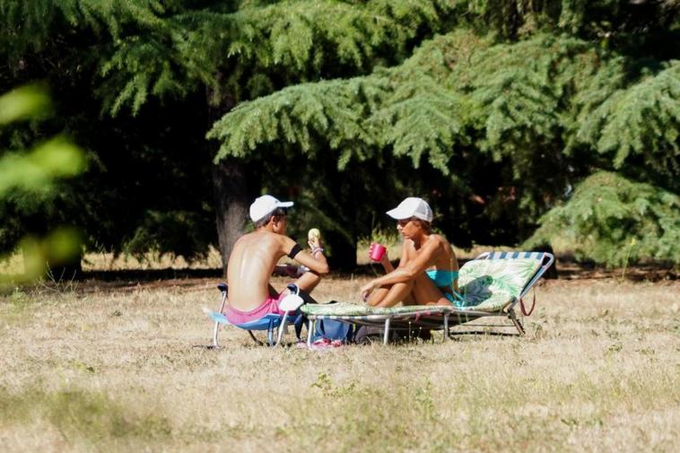 Dos personas toman el sol en los merenderos de La Aldehuela