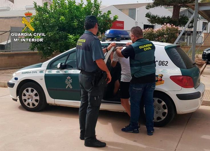 El detenido es introducido en el coche de la Guardia Civil