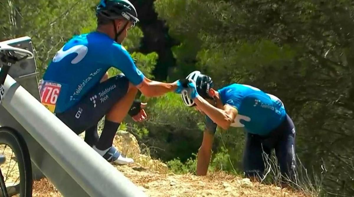 El ciclista Alejandro Valverde (Movistar Team) tras caerse en la séptima etapa de La Vuelta 2021, ayudado por su compañero José Joaquín Rojas.