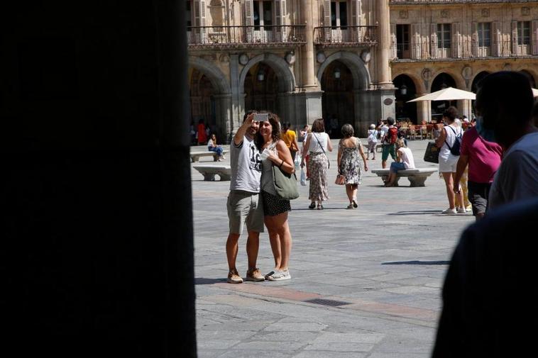 Una pareja de turistas se hace un selfie en la Plaza Mayor de Salamanca.