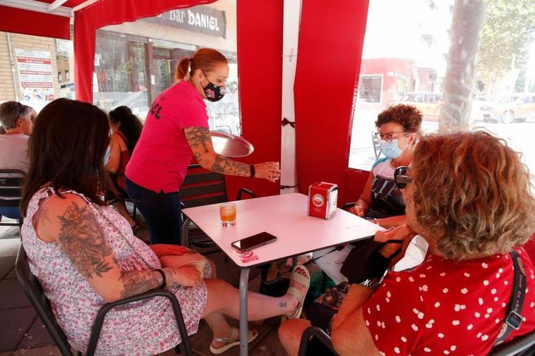 Una camarera sirviendo en una terraza de la ciudad.