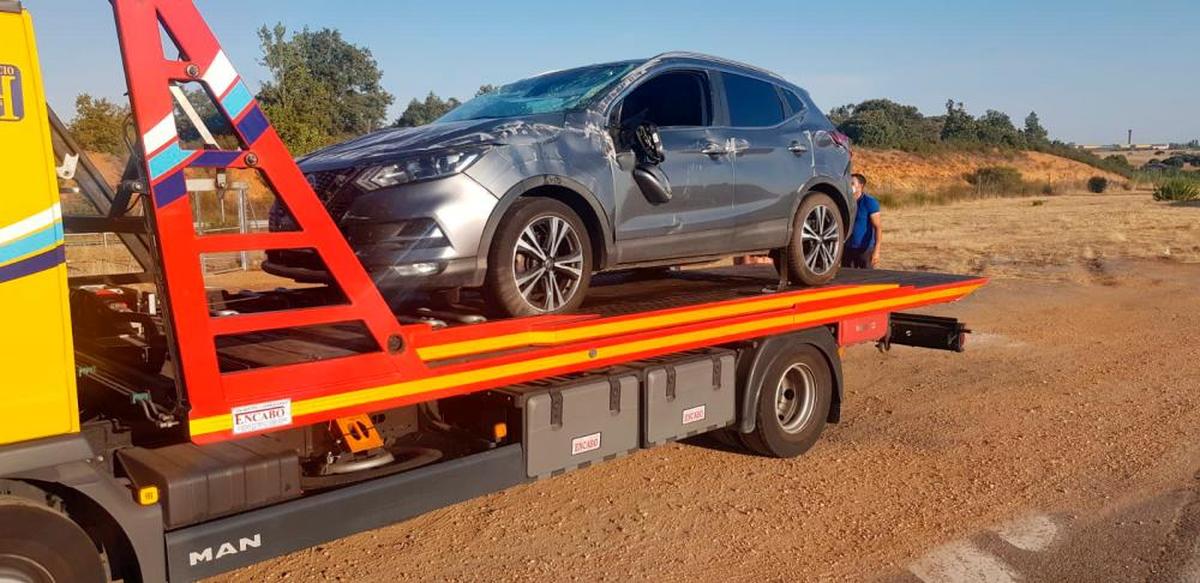 El vehículo accidentado, retirado por la grúa.