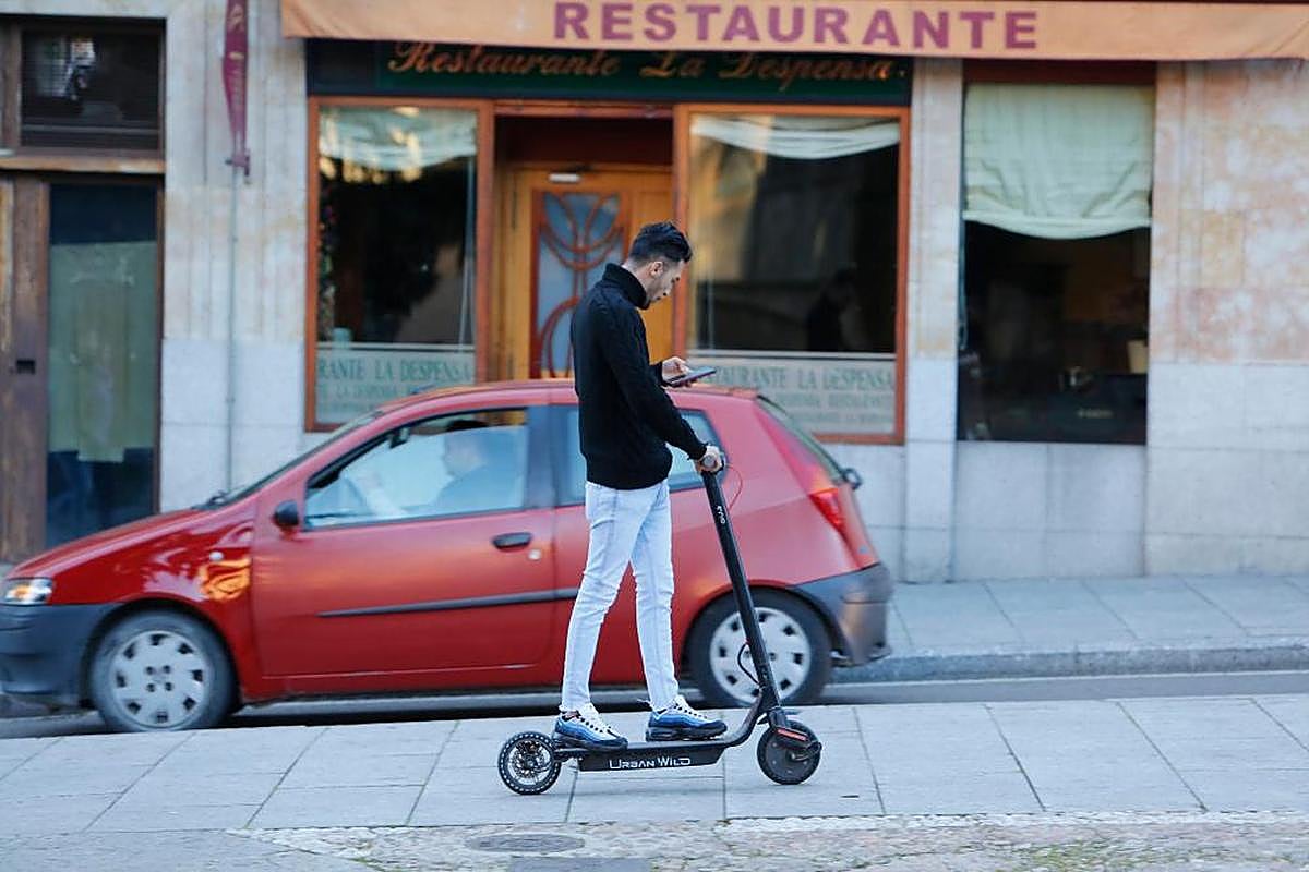 Un joven circula por Salamanca en un patinete eléctrico.