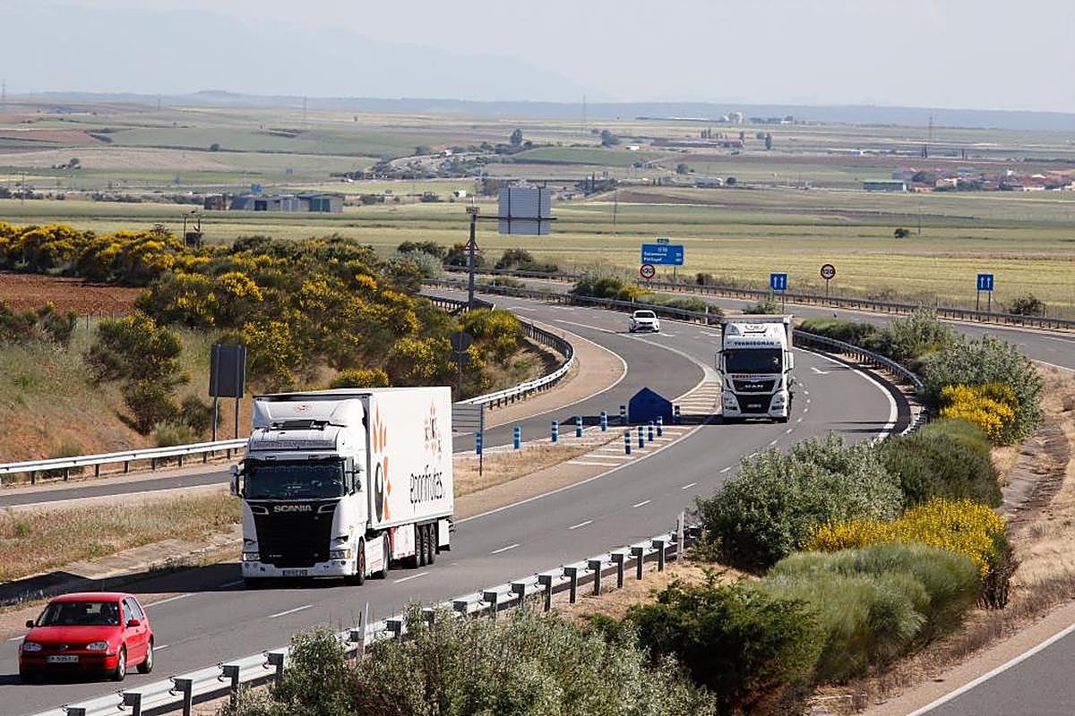 Dos camiones circulan por una autovía.
