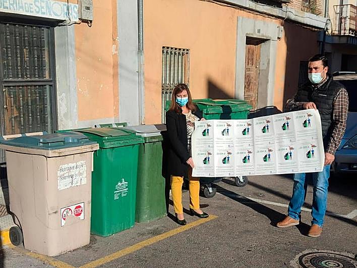 Carmen Ávila y Antonio Poveda muestran las pegatinas para los contenedores.