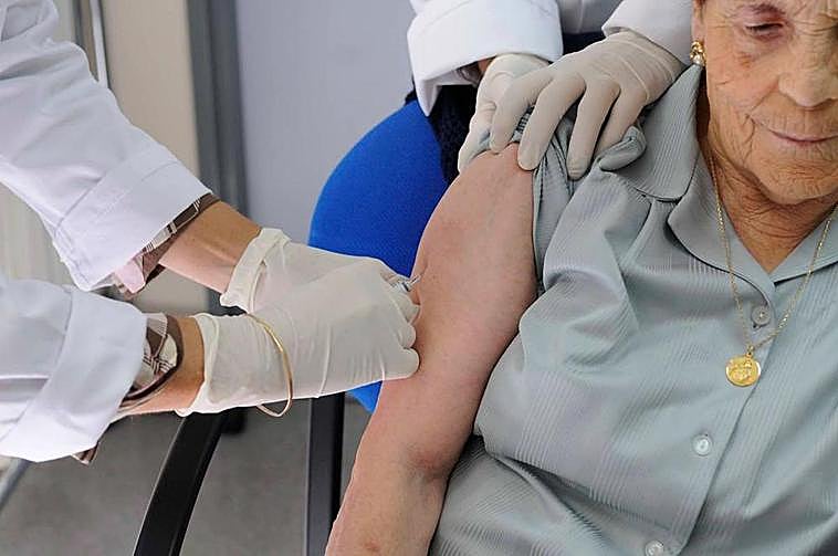 Una persona de avanzada edad recibe una dosis de vacuna.