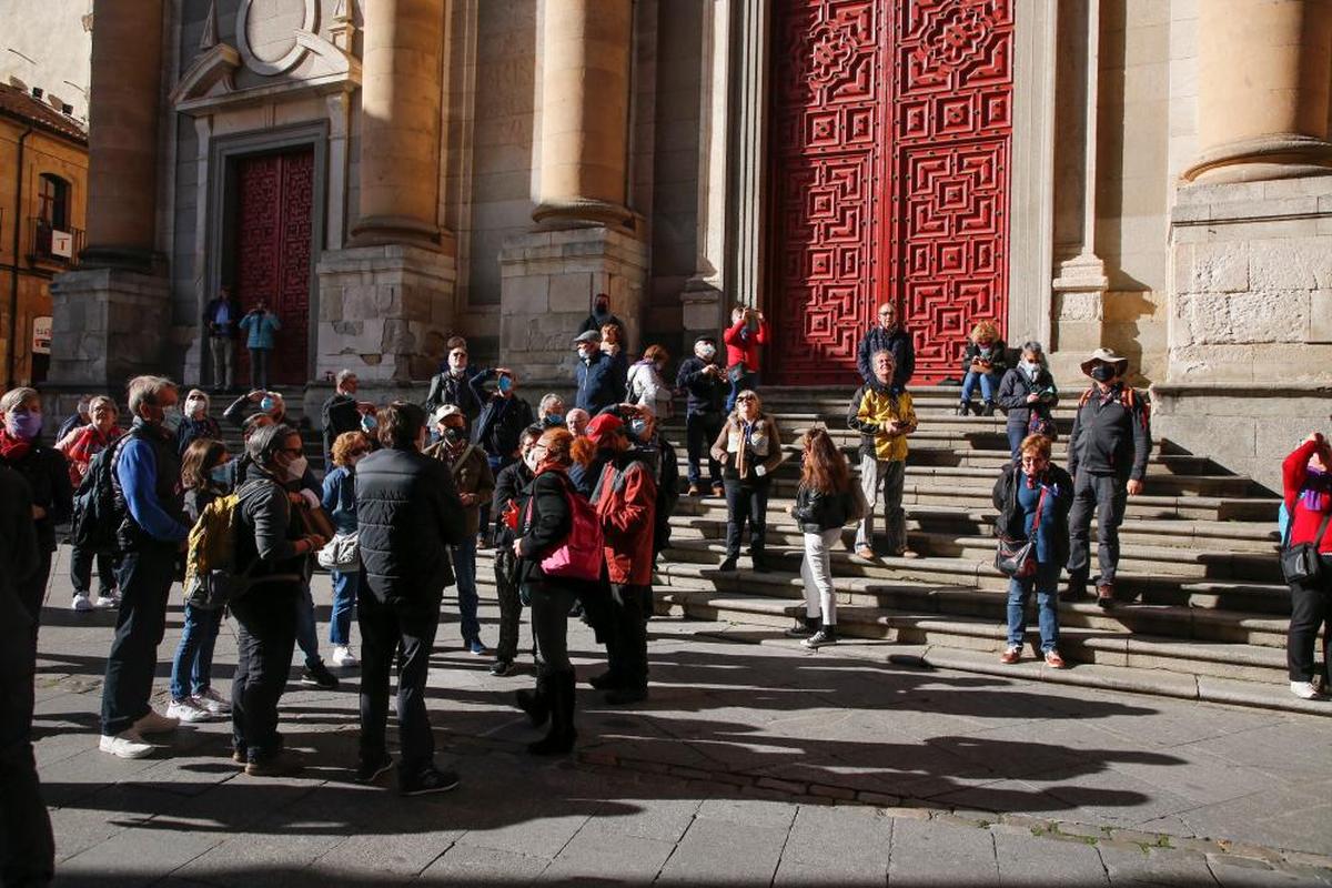 Un grupo de turistas extranjeros, en las escaleras de la iglesia de la Clerecía.