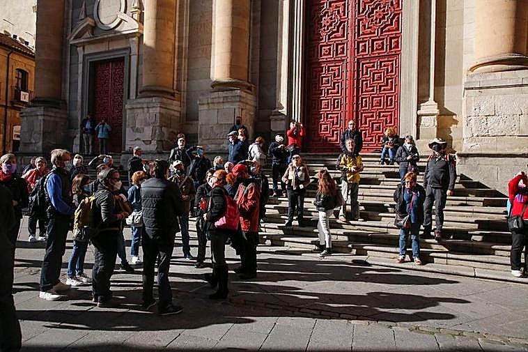 Un grupo de turistas extranjeros, en las escaleras de la iglesia de la Clerecía.