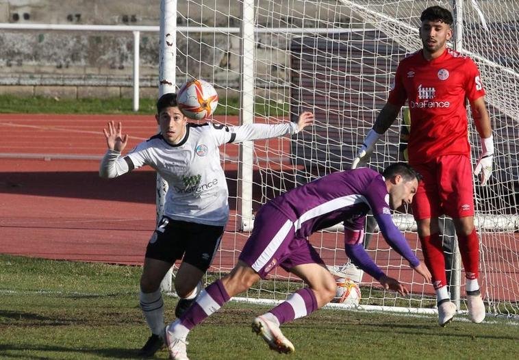 Verda, central del filial del Salamanca UDS, intentando despejar un balón en el área.