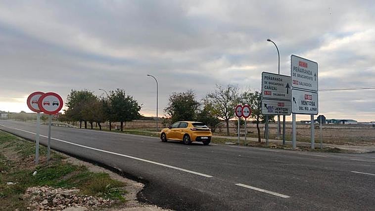 Un turismo circula por el acceso a Peñaranda en medio de la doble señalización vertical