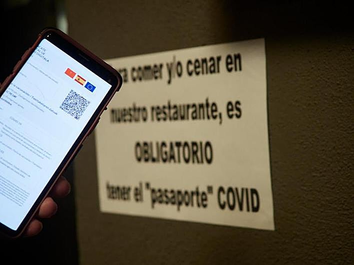 Una persona muestra su certificado de vacunación contra la covid